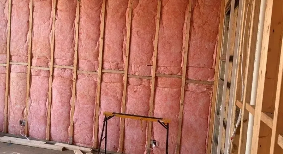 Pink fiberglass batt insulation installed in wall framing on a BC job site